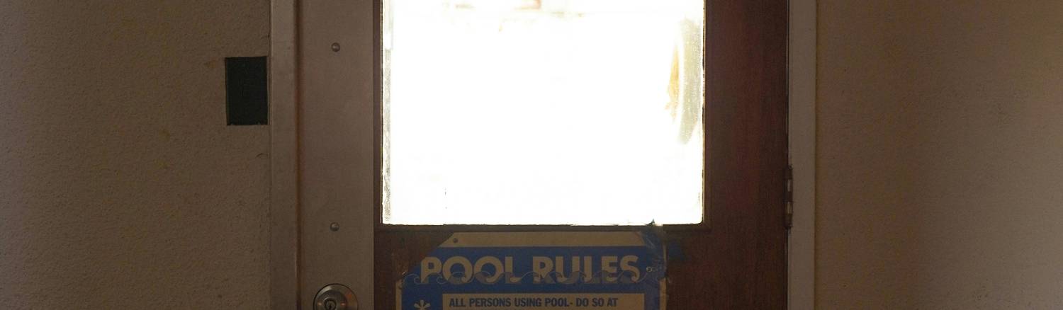 Eviction notice posted on a rental property door in Arizona, with residential building in the background