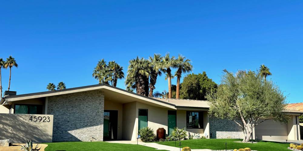 Modern Arizona rental home exterior with palm trees, blue sky, and tenants moving in