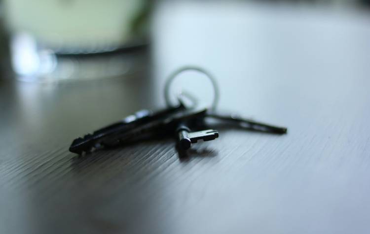 Tenant reviewing move-out inspection checklist with keys and cleaning supplies on a counter in an Arizona rental